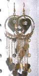 Circular gold fish hook earring with heart shape in middle and long chain holding mini heart shape chips