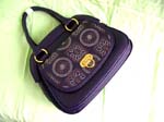 Accessory fashion wholesale factory catalog. Fun fashion handbag in imitation leather with decorative floral design on side pocket cover and double handles