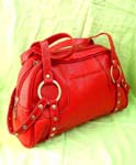 Evening wear accessories supplied by online import outlet. Red fashion handbag with silver hoops holding double handles and studded strap decor