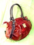 Trendy fashion accessory shopping supply catalog. Red imitation leather carry all bag with sequin print, double handles attaching with buckles and zippered pocket