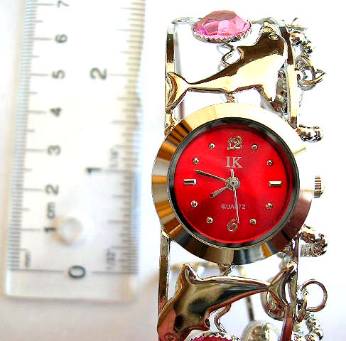 Beaded bangle watch from China import service agent with rounded clock face and carved-out pattern 
withjingle bells on band