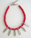 Fashion bracelet formed with multi rounded imitation coral beads paired with 6 imitation shark teeth dangling in center, lobster claw clasp