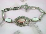 Wholesale silver jewelry catalog finding. Opaque light brown diamond shaped center with seashell embedded loosely connected long strip forming fashion bracelet, toggle clasp for closure