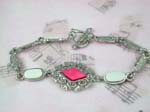 Wholesale jewelry and gifts for retail sale. Dark pink diamond shaped center with seashell embedded loosely connected long strip forming fashion bracelet, toggle clasp for closure