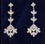 Costume gemstone jewelry distributor fpr fashions supply Floral themed earings with inlaid cz stones that extend from the flower stud to two leaf rows and then to a diamond shaped design with three leaf shapes.